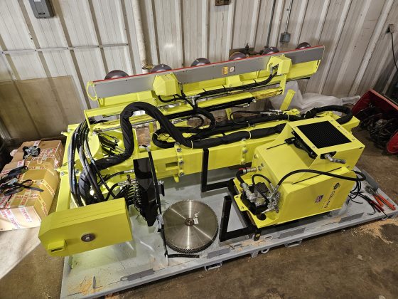 Pieces of a large yellow and black machine waiting to be assembled. 